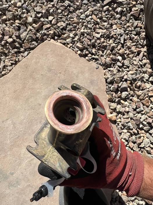 Technician connecting a refrigerant line fitting during AC installation